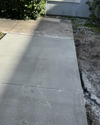 A finished poured-concrete sidewalk connecting a walkway on a completed job.